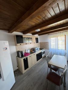 a kitchen with a table and a table and chairs at Cabana LUCI - FIGA in Beclean