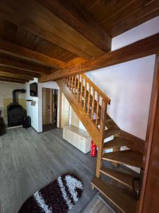 a wooden staircase in a living room with wooden floors at Cabana LUCI - FIGA in Beclean