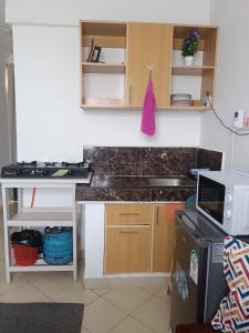 a small kitchen with a counter top and a microwave at Studio solace kitisuru in Nairobi +6 photos