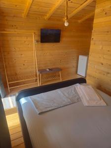 a room with a bed in a wooden cabin at Mar a Lago Glamping23 in Douăzeci şi Trei August +84 photos