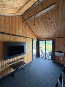 a room with wooden walls and a tv and a couch at СвояХата in Svityazʼ
