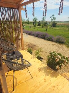a porch with a chair and a view of a field at Mar a Lago Glamping23 in Douăzeci şi Trei August