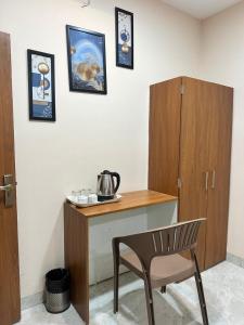 a room with a wooden desk with a chair at Hotel Prime Access Inn in Indore