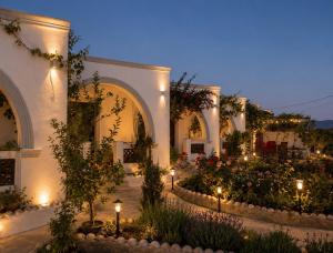 a courtyard with flowers and lights at night at Mihalis Studios in Karpathos