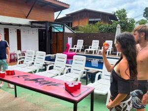 a man and woman standing next to a table next to a pool at K-Bunk Hostel Pai Walking Street in Pai +31 photos