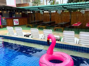 a pink swan in a pool with chairs and tables at K-Bunk Hostel Pai Walking Street in Pai