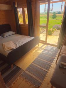 a bedroom with a bed and a large window at Mar a Lago Glamping23 in Douăzeci şi Trei August
