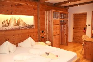 a bedroom with a bed and a painting on the wall at Hotel Der Tharerwirt in Valdaora +52 photos