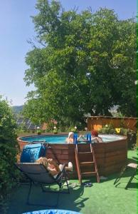 a woman laying in a chair next to a swimming pool at Rózsa apartman in Odorheiu Secuiesc