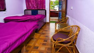 a room with two beds and a table and chairs at Hotel Padam Niwas in Ukhimath