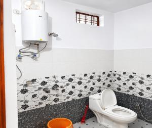 a bathroom with a toilet and a wall with flowers on it at Hotel Padam Niwas in Ukhimath +25 photos