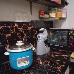 a slow cooker sitting on a counter next to a toaster at Hiru's Place in Gandara East