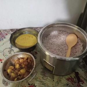 two pots of food on a counter with a wooden spoon at Hiru's Place in Gandara East