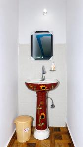 a bathroom with a sink and a tv on the wall at Hotel Padam Niwas in Ukhimath