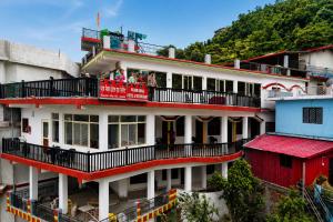 a building with people on the balcony of it at Hotel Padam Niwas in Ukhimath