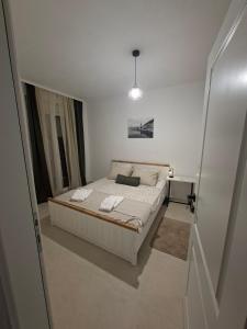 a bedroom with a bed in a white room at Apartmani EMMA in Kotor