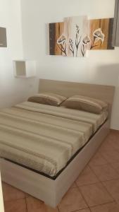 a bed in a white room with avertisement for at Fabian Appartament in Bagheria
