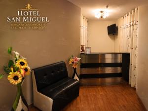 a waiting room with a leather chair and a piano at Hotel San Miguel in San Miguel