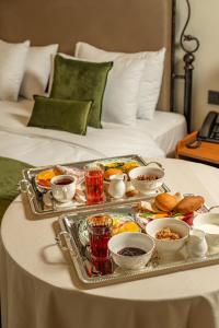 a tray of food on a table on a bed at Hayasa Hotel Old Yerevan in Yerevan