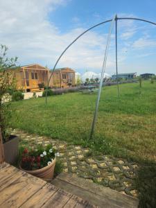 a garden with an arch and flowers in a yard at Mar a Lago Glamping23 in Douăzeci şi Trei August