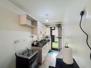 a small kitchen with a stove and a sink at The Escape Muthiga Waiyaki way in Nairobi