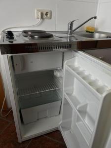 a refrigerator with its door open and a sink at Twin Studio in Boizenburg