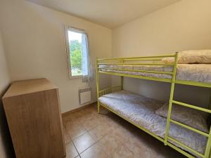 a bedroom with two bunk beds and a window at Appartement T3 Barbaste in Barbaste