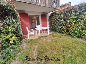 a patio with a table and chairs in a yard at Appartement T3 Barbaste in Barbaste