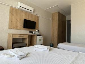 a hotel room with two beds and a flat screen tv at Özsoy Otel in Akçay