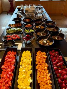 a long table with a buffet of fruit and vegetables at Das Panorama Dependance in Caldaro