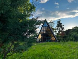 a small house with a glass window on a field at Ja ge • ჟა ღე in Tsalka
