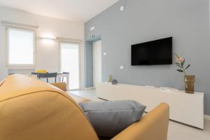 a living room with a couch and a tv on a wall at GuestHost - Vivaldi Estate Apartment in Treviglio