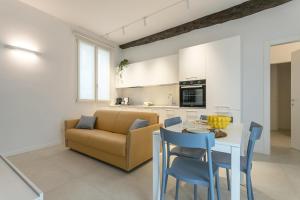 a living room with a couch and a table and chairs at GuestHost - Vivaldi Estate Apartment in Treviglio