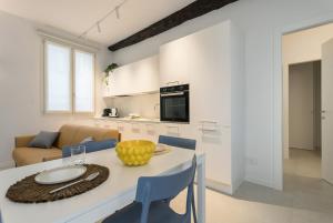 a kitchen and living room with a table and chairs at GuestHost - Vivaldi Estate Apartment in Treviglio +11 photos