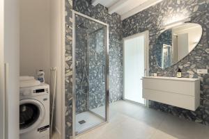 a bathroom with a washing machine and a mirror at GuestHost - Vivaldi Estate Apartment in Treviglio