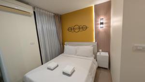 a bedroom with a white bed with two books on it at Boat Avenue condo in Bang Tao Beach +24 photos