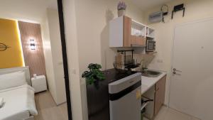 a small kitchen with a black refrigerator and a sink at Boat Avenue condo in Bang Tao Beach