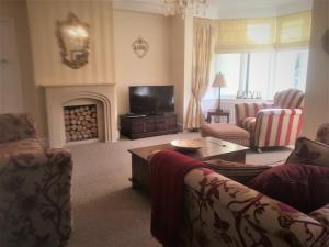 a living room with two couches and a fireplace at Fring House Apartment in Seaton