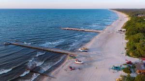 an aerial view of a beach with boats in the water at MEDUSA apartamenty i bungalowy in Niechorze
