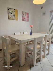 a white table and chairs with a vase of flowers on it at Apartment with three double bedrooms in Altavilla Vicentina