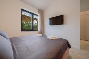 a bedroom with a bed and a flat screen tv at House 61 in Milotski Breg