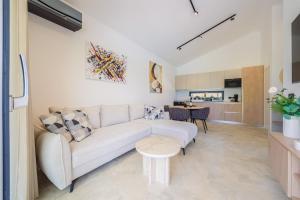 a living room with a white couch and a table at House 61 in Milotski Breg