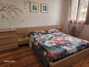 a bedroom with a bed with a floral bedspread at Apartment with three double bedrooms in Altavilla Vicentina