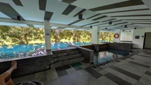 a person taking a picture of a swimming pool in a building at Boat Avenue condo in Bang Tao Beach