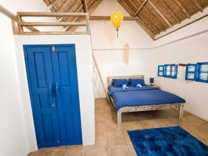 a bedroom with a blue bed and a blue door at Bali Bio Villas in Uluwatu +80 photos