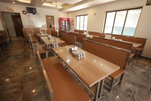 a dining room with tables and chairs in a restaurant at Hotel Rangoli Dharampur in Dharampur