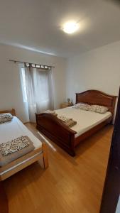two beds in a room with wooden floors at UnaMar 1 in Prčanj