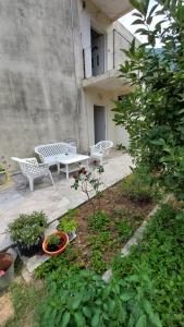a patio with two benches and a table and plants at UnaMar 1 in Prčanj