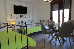 a bedroom with two beds and a table and chairs at Dimitra Apartments in Sitia