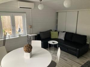 a living room with a black couch and a table at Compact living Laxvik in a cottage in Halmstad